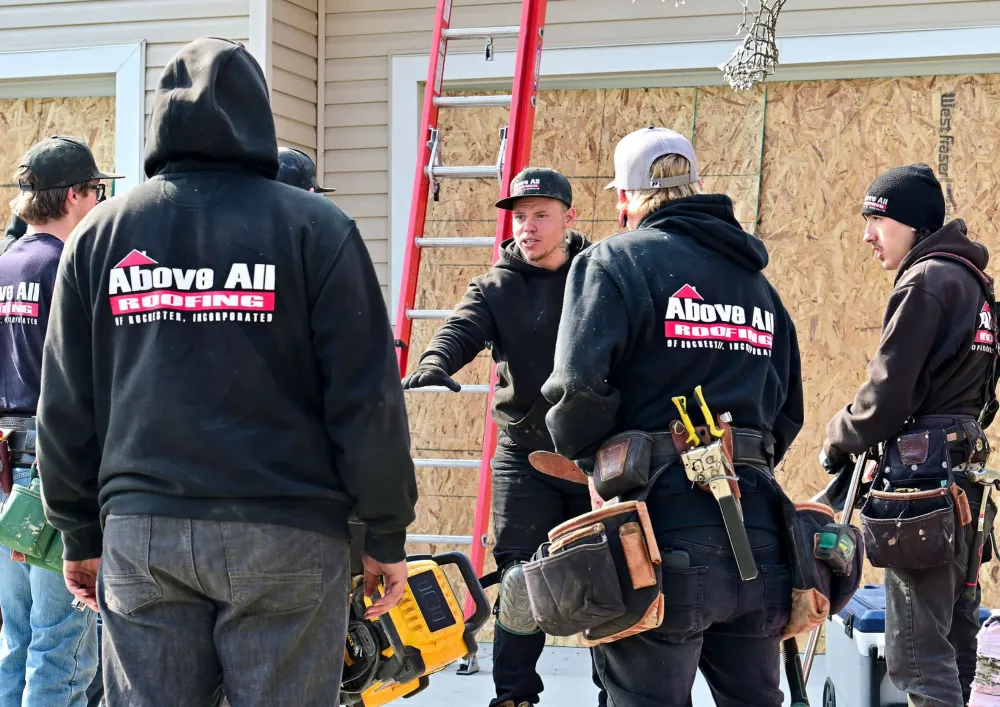 Roofing team discussing roof leak repair strategies during an on-site meeting in Rochester, Minnesota