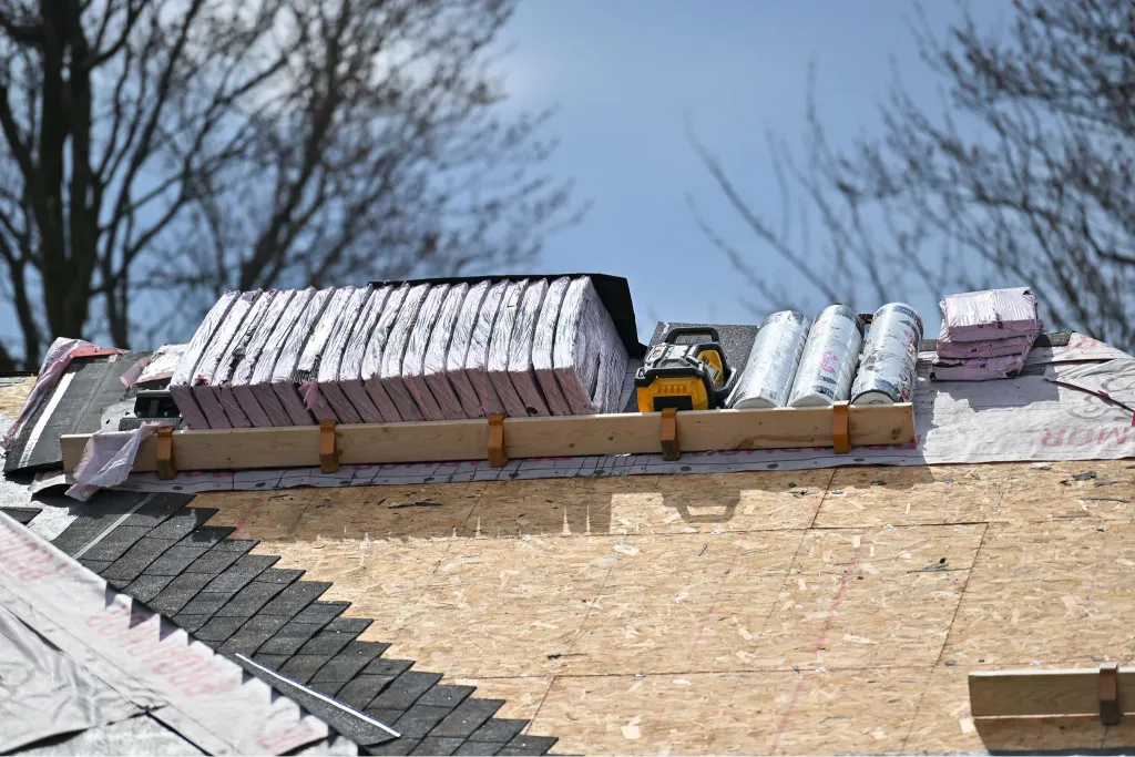 Roofing team replacing old shingles with new materials on residential home for improved durability