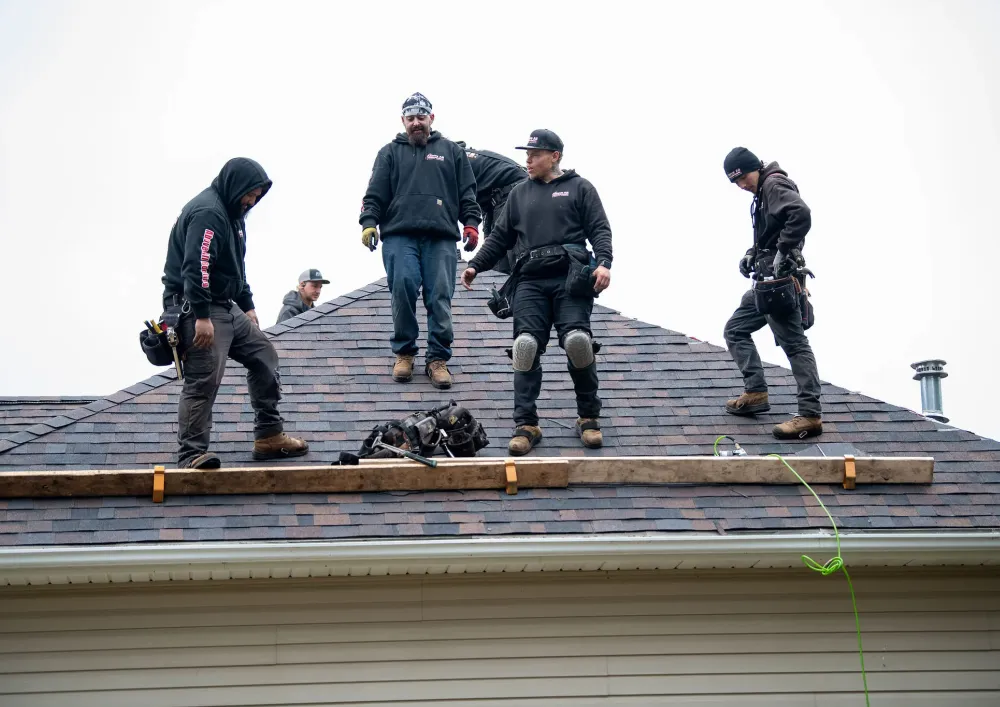 Team of professional roofing contractors installing new shingles on a residential home in Rochester, Minnesota