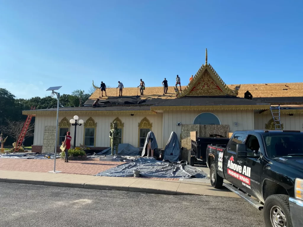 Above All Roofing professionals navigating a steep church roof during a full re-roof installation