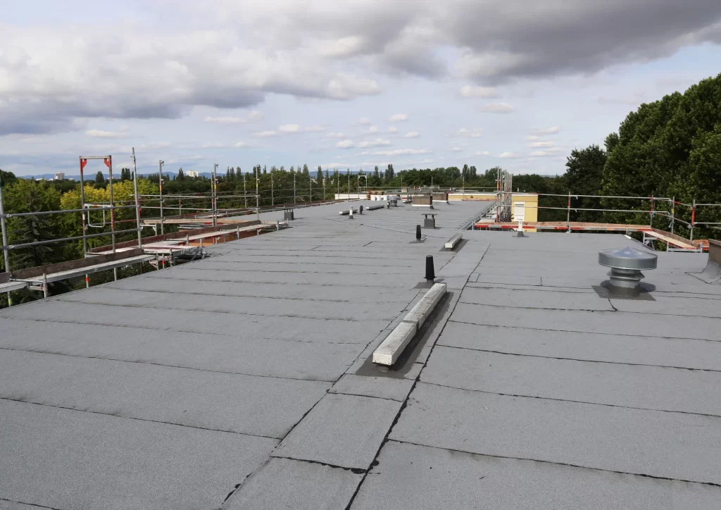 Flat roof showing signs of wear and potential leak areas, roofing inspection by Above All Roofing