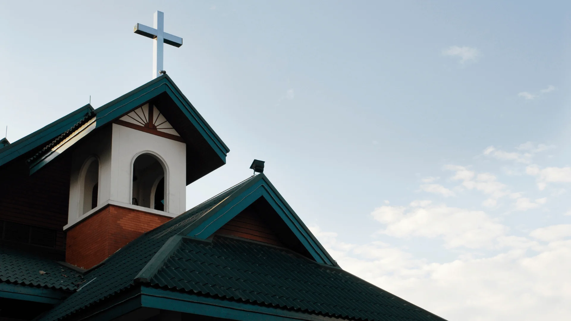 Church roof with steep gables and cross