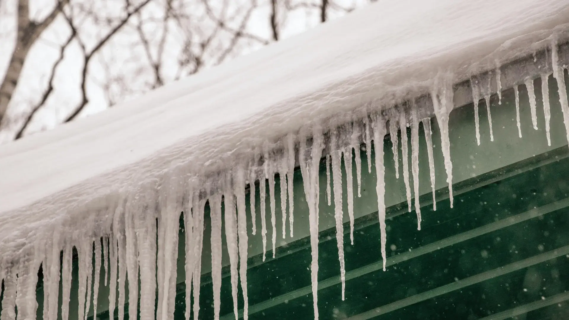 Icicles and snow buildup on a metal roof during winter