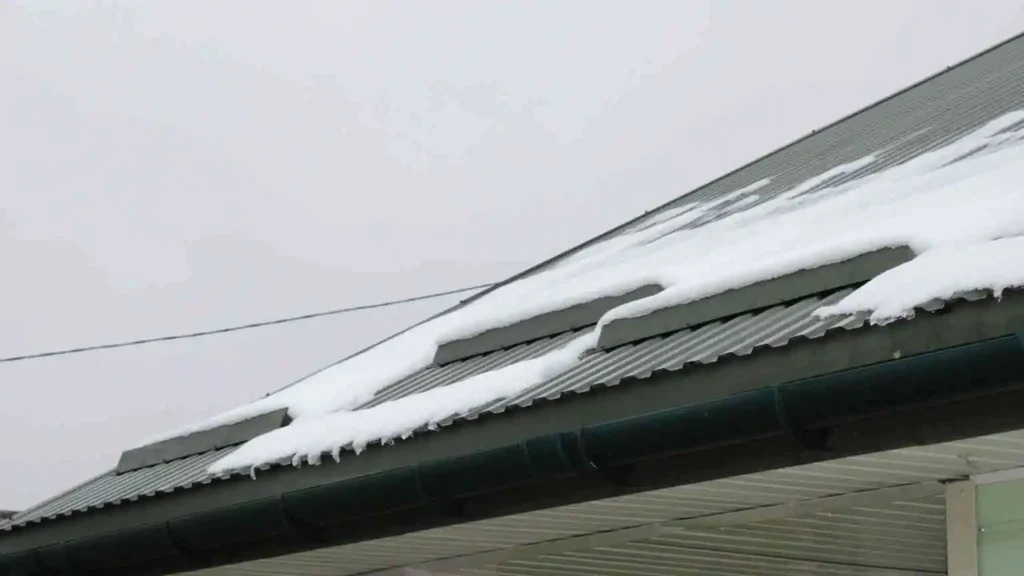 Metal roof shedding snow, showing durability in harsh winter conditions