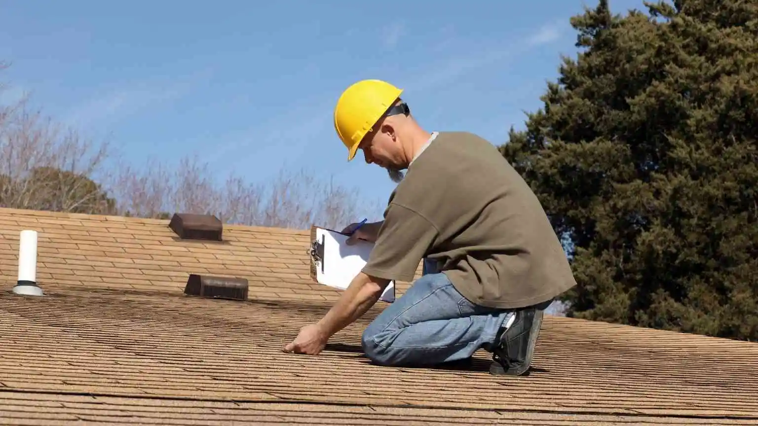 Roofing contractor inspecting a residential roof